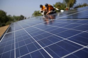 Solar technicians install solar panels on the roof of a house October 25, 2013.