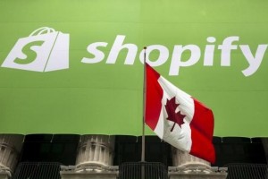 The logo of Shopify hangs behind the Canadian flag after the company's IPO at the New York Stock Exchange