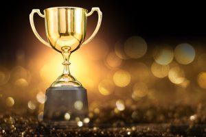 trophy over wooden table and dark background