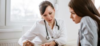 Image of a doctor talking to woman in an office.