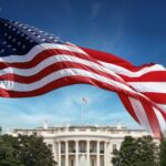 Photo of American flag flying in front of White House.