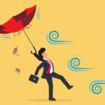 Image of businessperson struggling against wind.